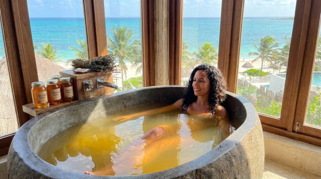 Baños de Miel Orgánica: El elixir ancestral para una piel radiante y joven mujer se baña en tina con miel organica